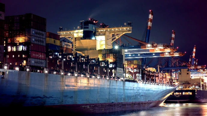 A large cargo ship in a harbor at night